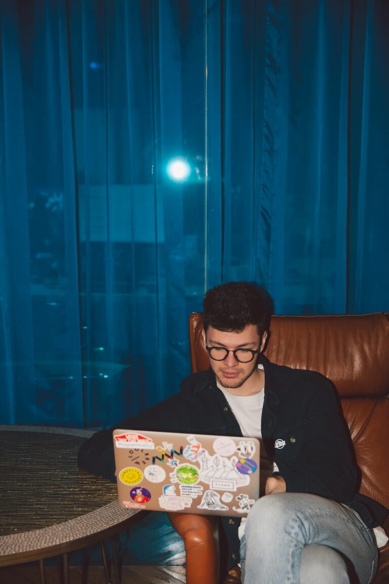 Man in Black Blazer Holding Laptop